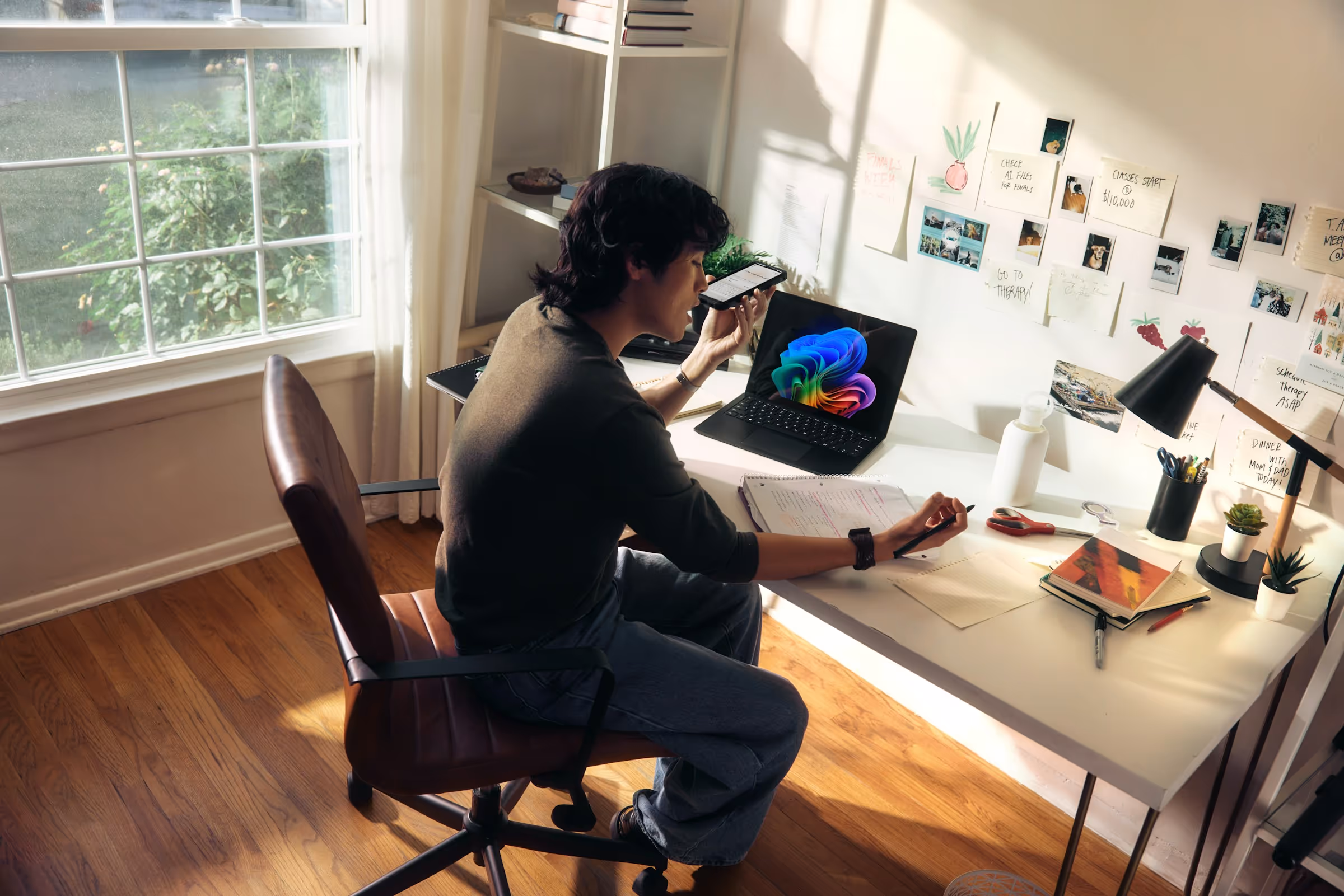 A person reviewing a tool at a sunlit desk with a laptop and notes